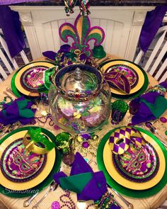 the table is set with purple, green and gold decorations for mardi gras