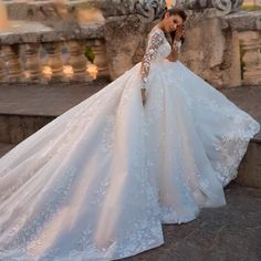 a woman in a wedding dress standing on some steps