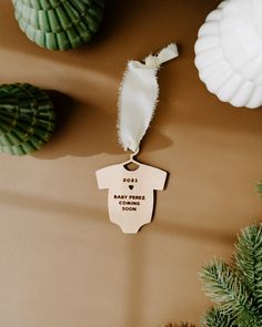 a baby's first christmas ornament hanging from a pine tree next to other ornaments