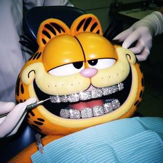 a person is getting their teeth brushed at the dentist's office with a tiger mask on