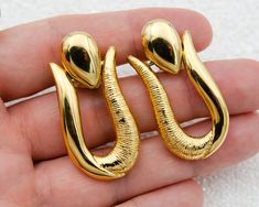 Vintage chunky oval gold door knocker clip on earrings. Excellent condition (please see photos).  Ready to ship, gift wrap is included. DETAILS: ♥ material: polished gold tone metal, textured gold tone metal ♥ approx. size: 1.75 x 0.75 inch / 4.5 x 2 cm ♥ style: 1980's ♥ type: non pierced earrings / massive earrings  ♥ unsigned  ♥ from smoke-free home Please note that all items in my shop are vintage and may have signs of wear and age including scratches, tarnishing etc. Please see photos for qu Door Knocker Earrings, Non Pierced Earrings, Gold Door, Door Knocker, Door Knockers, Gold Texture, Pierced Earrings, Gold Tone Metal, Earings Piercings