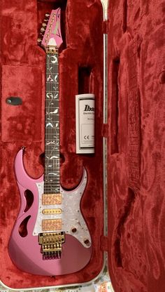 a pink electric guitar in its case