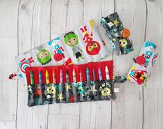 an assortment of children's pens and pencils on a white wooden table with various designs