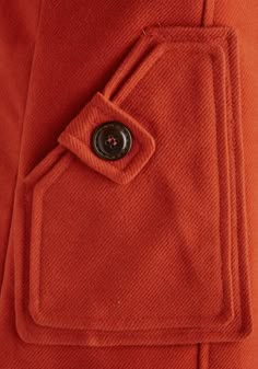 an orange jacket with a button on it