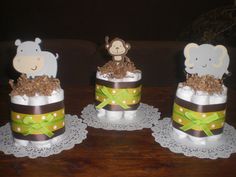 three diaper cakes decorated with animals and ribbons