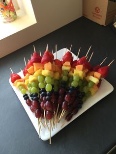 fruit skewers are arranged on a white plate