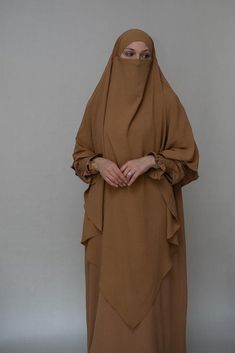 Introducing the Avalom Prayer Gown Umrah Abaya Dress in Brown by Annah Hariri, the perfect addition to your modest wardrobe. This elegant one-piece abaya dress is made from non-wrinkling fabric, ensuring that you always look put-together without the hassle of ironing.Featuring a classic A-cut design, this abaya dress offers ample coverage, making it suitable for any prayer occasion. It also comes with pockets, making it functional and convenient for carrying your essentials. The beautiful sleeve Modest Brown Maxi Dress, Modest Solid Color Niqab, Modest Long Brown Maxi Dress, Brown Khimar For Eid, Brown Long Sleeve Khimar For Eid, Brown Long Thobe For Eid, Modest Brown Abaya For Eid, Umrah Abaya, Annah Hariri