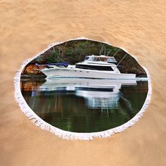 a white boat is docked in the water on a sandy beach with trees around it