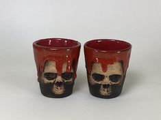 two red and black cups with skulls painted on them