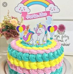 there is a cake that has been decorated with rainbows and unicorns on it