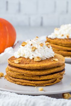 stack of pumpkin pancakes with whipped cream on top