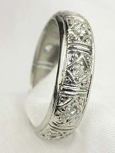 a white gold wedding ring with diamonds on the sides and inlays to it