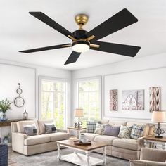 a living room with couches, tables and a ceiling fan in the middle of it