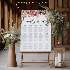 a seating chart with flowers and greenery is displayed next to two small vases