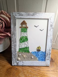 a picture frame that is made to look like a beach scene with a lighthouse and starfish