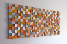 an orange, grey and white wall hanging on the wall