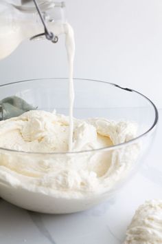 a bowl filled with whipped cream being poured into it