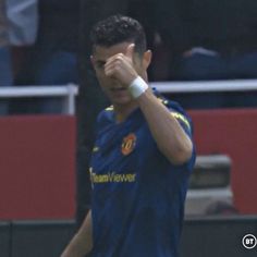 a soccer player wiping his eyes on the field