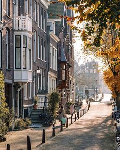 people are walking down the street in front of some buildings and bicycles parked on the sidewalk