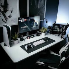 a desk with two computer monitors and a keyboard on it in front of a black wall