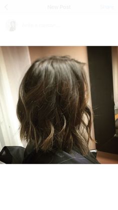 the back of a woman's head in front of a mirror with her hair pulled back