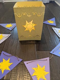 a box that is sitting on the floor with paper sun decorations around it and string