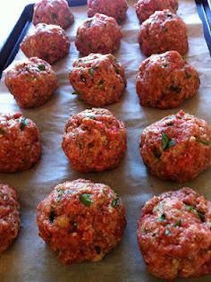 raw meatballs on a baking sheet ready to go into the oven or grilling