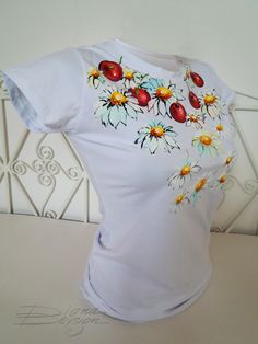 a white t - shirt with ladybugs and daisies on it