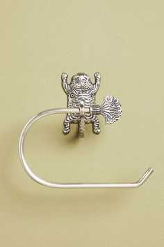 a metal towel ring with a monkey on it's back hanging from a wall