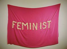 a pink banner with the word feminist written on it