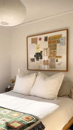 a bed with white sheets and pillows in a bedroom