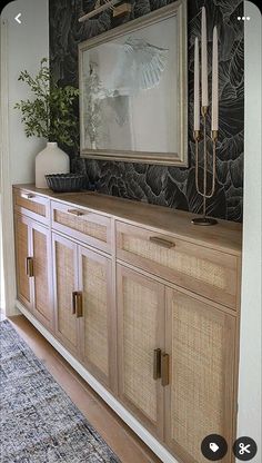 an image of a room setting with black and white wallpaper, bamboo cabinet doors and artwork on the wall