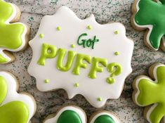 some decorated cookies with green icing and shamrocks on the top one says got puffs?