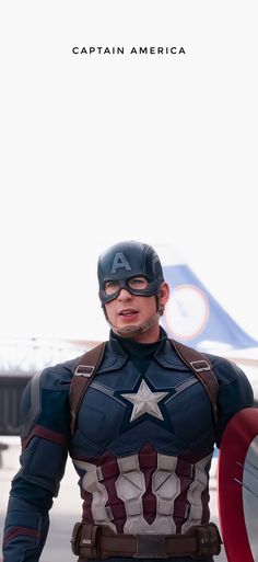 captain america is standing in front of an airplane