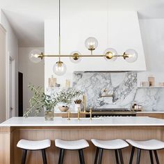 a kitchen with marble counter tops and white stools