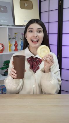 a woman holding a cup and a cookie