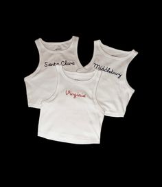 White cropped fitted tank tops with any phrase hand embroidered! The phrase will be embroidered exactly as written in the personalization section, so please make sure to use capital or lowercase letters as intended. Casual Embroidered Fitted Tank Top, Fitted Sleeveless Crop Top With Letter Print, Fitted Sleeveless Letter Print Crop Top, Embroidered Stretch Cotton Tops, Fitted Summer Tops With Embroidered Graphics, Casual Embroidered Sleeveless Crop Top, Casual Fitted Top With Custom Embroidery, White Embroidered Cotton Tank Top, Fitted Letter Print Tank Crop Top