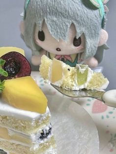 a small doll is sitting next to a piece of cake on a plate with fruit