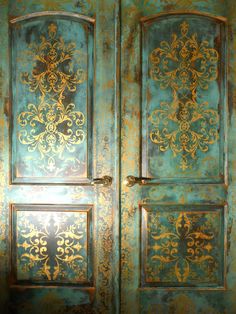 an ornately painted wooden door with gold and blue paint on the doors, which are decorated