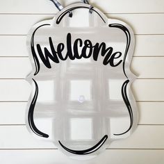 a welcome sign hanging from the side of a wall