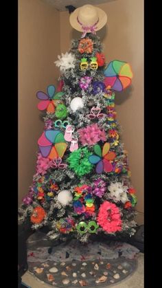 a decorated christmas tree in the corner of a room with hats on top and other decorations around it