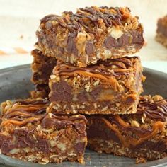 several pieces of chocolate and pecan bars stacked on top of each other in a bowl