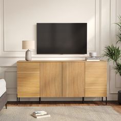 a living room with a large flat screen tv on top of a wooden entertainment center