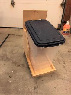 a plastic container sitting on top of a wooden stand in a garage next to a wall