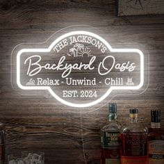 the jackson's backyard oasis neon sign on a wooden wall with liquor bottles