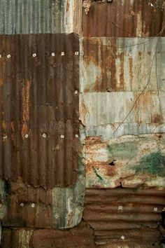 an old rusted metal wall with peeling paint and rivets on it stock photos