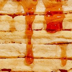 peanut butter and jelly sandwiches are stacked on top of each other with syrup dripping from them