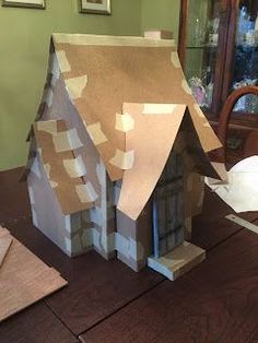 a house made out of cardboard sitting on top of a table