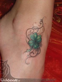 a woman's foot with a clover tattoo on it