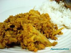 a white plate topped with rice and meat